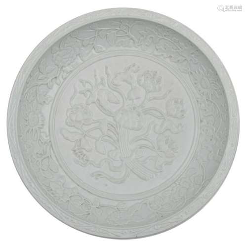 A Chinese floral relief decorated white glazed charger,