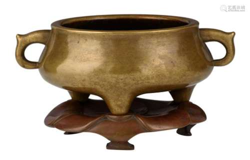 A Chinese archaic bronze gui tripod incense burner on a