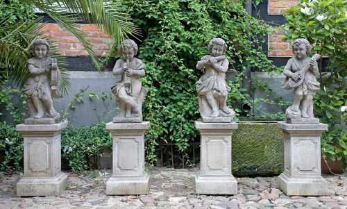 Vier musizierende Amorettenals Parkskulpturen. Hellgrauer Sandstein. Vollplastisch gestaltete Putten
