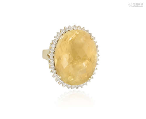 A CITRINE AND DIAMOND COCKTAIL RING, the oval mixed-cut citrine set within a surround of round