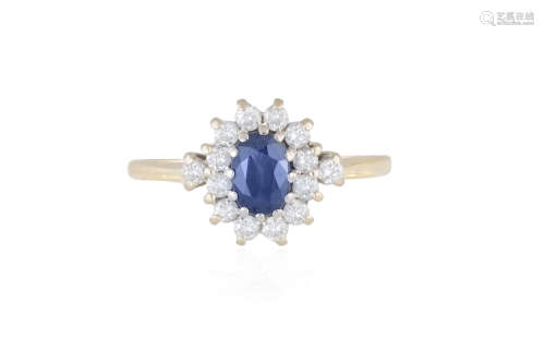 A SAPPHIRE AND DIAMOND CLUSTER RING, the oval-shaped sapphire within a surround of round brilliant-