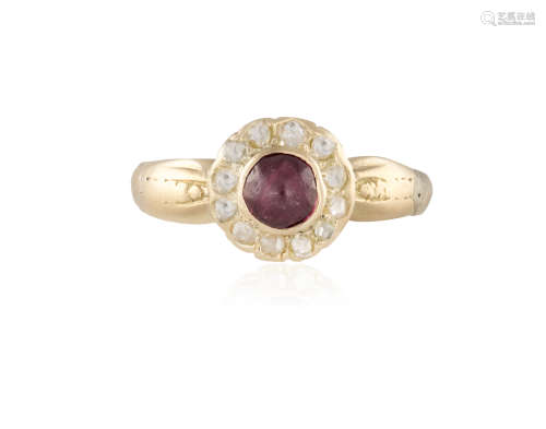A GARNET AND DIAMOND RING, the round-shaped cabochon garnet set in closed-back setting, within a