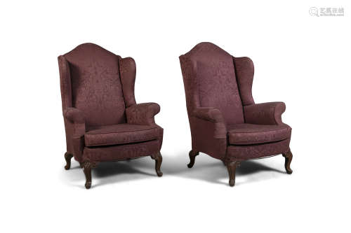 A PAIR OF MAHOGANY FRAMED WING BACK ARMCHAIRS, in early Georgian style, covered in a claret