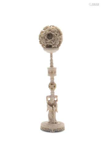 A CHINESE CARVED IVORY PUZZLE BALL ON STAND, 19th century, the pierced sphere supported on a cup and