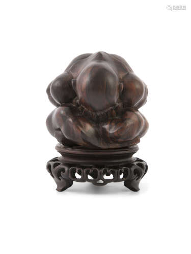 A CARVED HARDWOOD SCULPTURE OF A CROUCHED FIGURE, on Chinese pierced stand. 13cm high