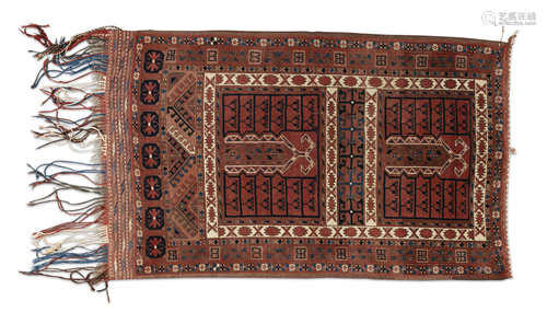 A TEKKE WOOL CARPET, c.1900, of rectangular form, woven in cream, red and navy tones, with four