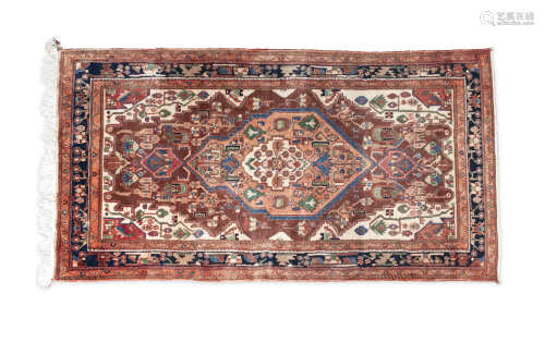 A RED GROUND WOOL RUG, with central lozenge design, woven with flowerheads, leaves and motifs inside