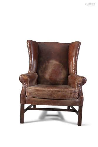 A GEORGE III MAHOGANY FRAMED WINGBACK ARMCHAIR, covered in dark brown leather, with outscrolling