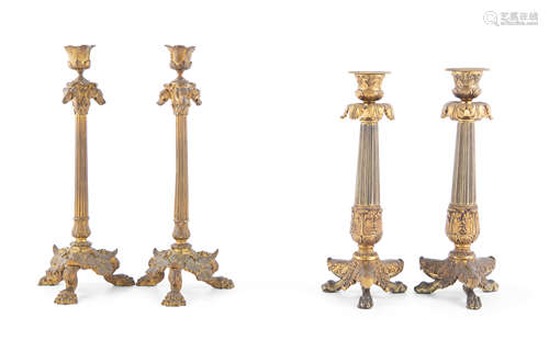 A PAIR OF FRENCH GILT BRONZE FLUTED CANDLESTICKS, with leaf cast nozzles, above dog masks and