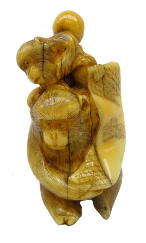 Japanese Meiji ivory Okimono carved as two Monkeys holding a banner, H6.