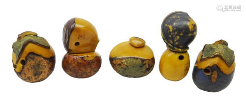 Five Japanese Meiji carved Tagua nut Netsukes each decorated with metallic pigment,