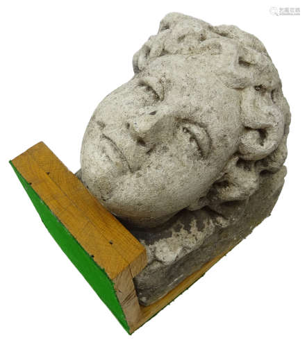 Carved stone corbel carved with a female head, mounted on oak stand, D29cm,