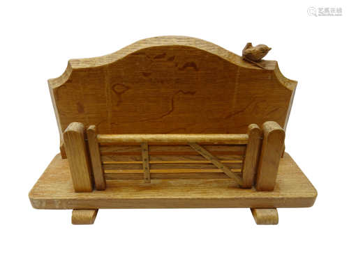 'Wrenman' oak letter rack, with five bar gate, the shaped back with carved wren signature,