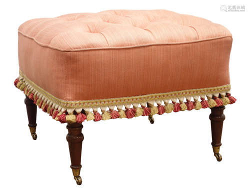 Square footstool upholstered in salmon fabric, deep buttoned top with tasselled fringe,