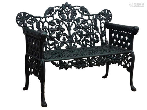 Victorian style cast iron garden bench, with ornate leaf back and lattice arms on scroll feet,