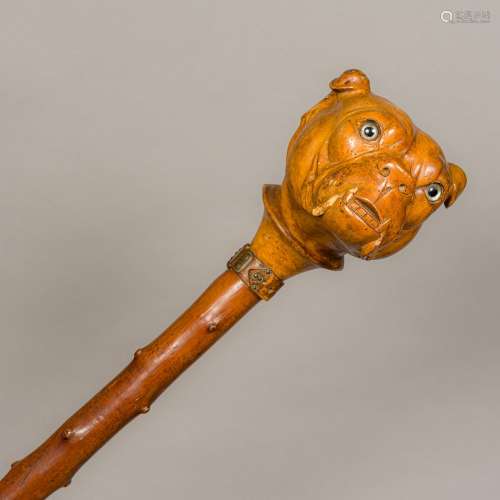 A 19th century carved wooden treen walking stick The bulbous handle formed as a bulldog head with
