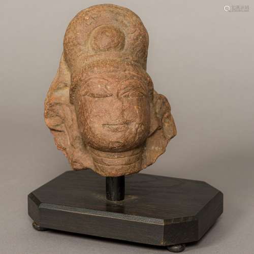 An antique, possibly 12th century, Eastern carved red sandstone head Carved as an Indian deity,
