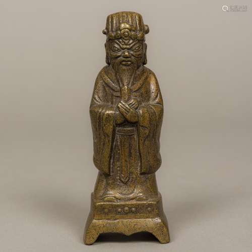 A Chinese bronze figure of an attendant Modelled hands crossed and wearing a headdress.