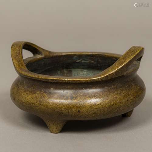 A Chinese patinated bronze censer Of squat form with twin handles,