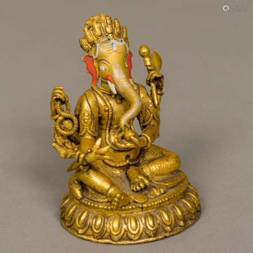 A small gilt bronze model of Ganesh Modelled seated and with painted detail. 10 cm high.