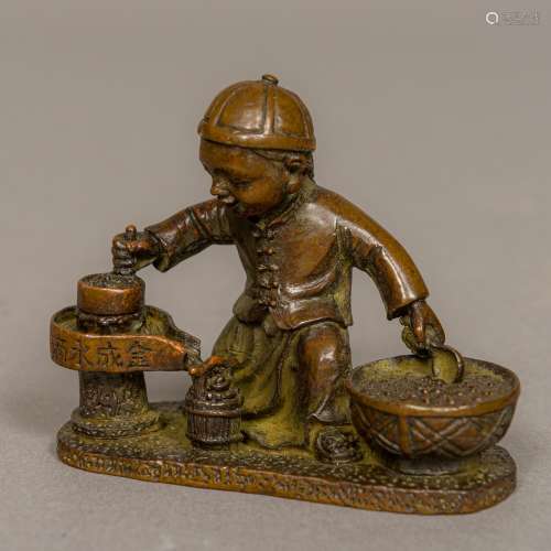 A Chinese bronze group worked as a young street vendor juicing fruit Incised mark. 6.5 cm high.