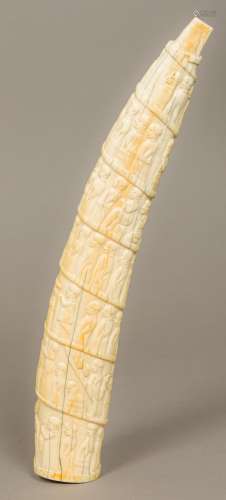 A late 19th/early 20th century carved tusk Worked in the round with a procession of figures.