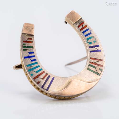 A Russian enamel decorated silver brooch Of horseshoe form, with calligraphic decoration,