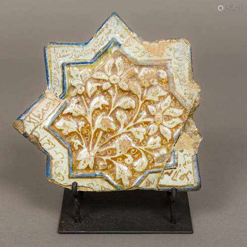 An antique Kashan tile Of star form, decorated with floral sprays in a script filled border,