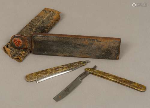 A cased pair of 19th century pressed horn handle cutthroat razors Each decorated with intertwined