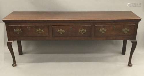 A George III oak low dresser The moulded rectangular top above three frieze drawers with brass