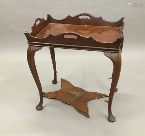 An Edwardian 18th century style mahogany silver table The shaped pierced tray style top supported