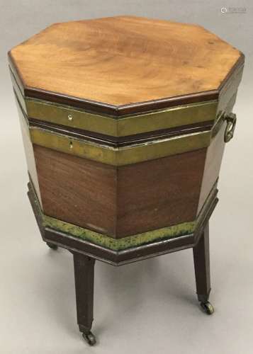 An early 19th century mahogany cellaret Of brass bound octagonal form with hinged lid enclosing the