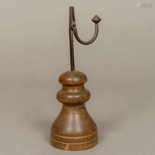 An antique rushnip The wrought iron brush holder mounted on a turned wooden plinth base.
