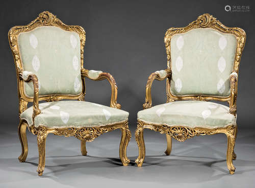 Pair of Continental Rococo-Style Giltwood Fauteuils , rocaille crest, foliate scrolled arms,