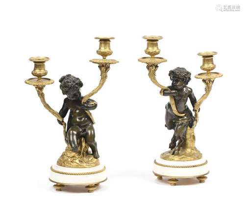 Paire de candélabres en bronze patiné et doré à deux feux de lumière, ornés [...]