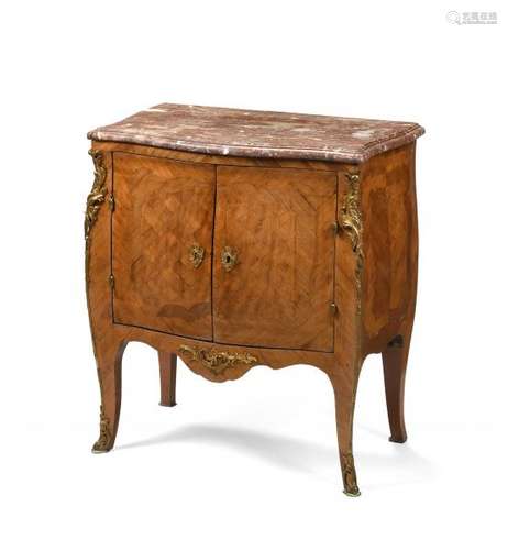 Petite commode à façade légèrement mouvementée en placage de bois exotiques, [...]