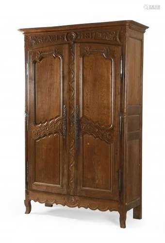 Armoire de mariage en chêne mouluré et sculpté ouvrant par deux portes à [...]