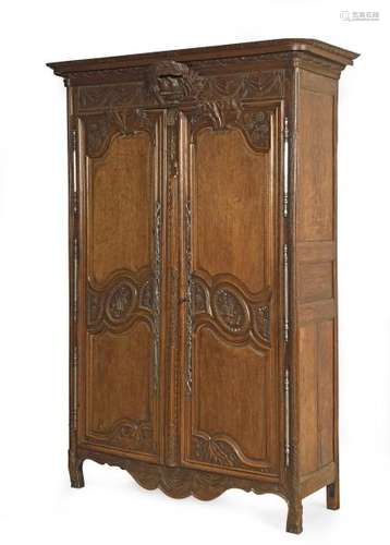 Armoire de mariage en chêne mouluré et richement sculpté ouvrant par deux portes, [...]