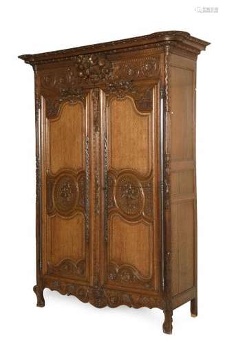 Armoire de mariage en chêne mouluré et richement sculpté ouvrant par deux portes, [...]