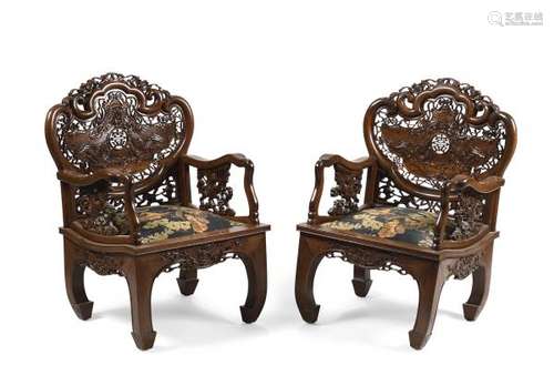 Paire de fauteuils en bois exotique mouluré, ajouré et sculpté, les dossiers à [...]