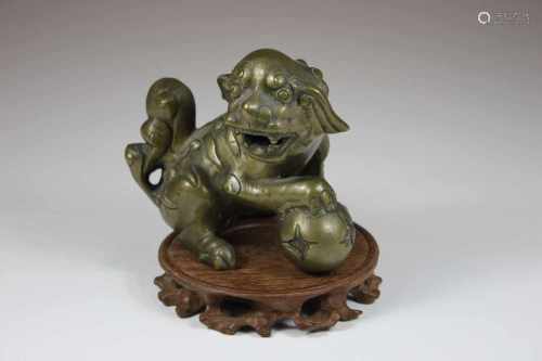 Fo-Hund, China 19. Jh., Bronze, sitzend mit rechtem Vorderbein auf Kugel, H.: 11,5 cm.