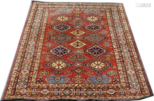 Tapis Kazak. Le fond, rouge, présente des médaillo…