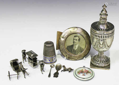 An Edwardian silver sugar caster of urn form with embossed ram's mask and swag decoration, on a