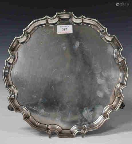 A George V silver salver with piecrust border and volute scroll feet, Chester 1931 by S. Blanckensee