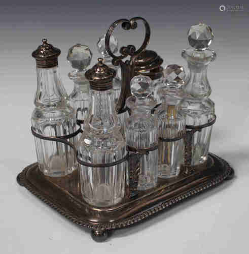 A George III silver cruet stand with central scroll handle and pierced frame, on a rectangular