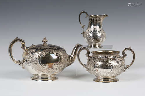 A Victorian silver three-piece tea set of circular form, engraved with flowers and foliate