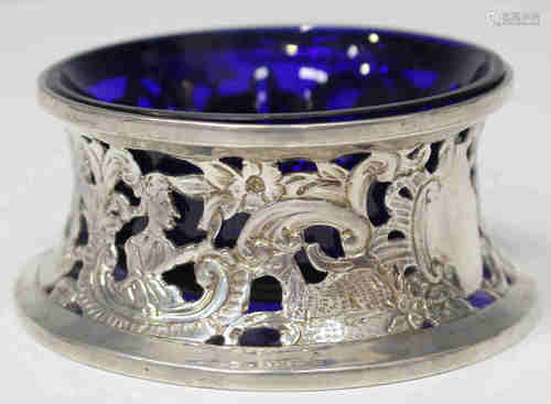 A late Victorian silver table salt in the form of an Irish dish ring, decorated in relief and