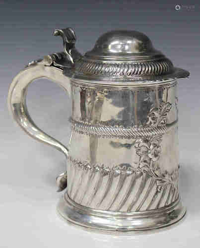 A George I silver tankard with domed hinged lid and scroll thumbpiece, the cylindrical body with