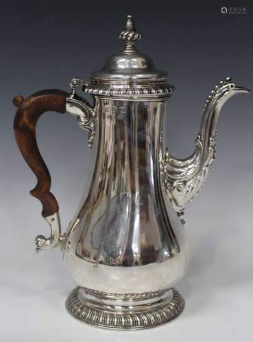 A George III silver coffee pot, the domed hinged lid and spiral reeded knop finial above a low