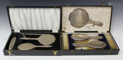 A George V silver backed five-piece dressing table set, comprising a hand mirror, a pair of